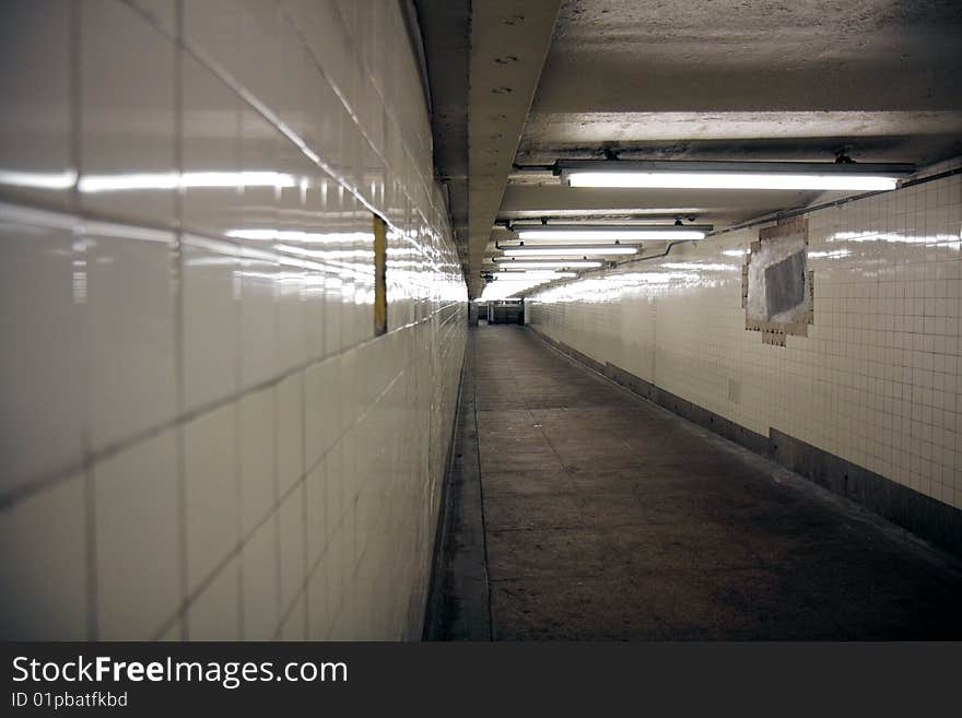 A tiled subway walkway at a Brooklyn subway station, shot with shallow depth of field. A tiled subway walkway at a Brooklyn subway station, shot with shallow depth of field