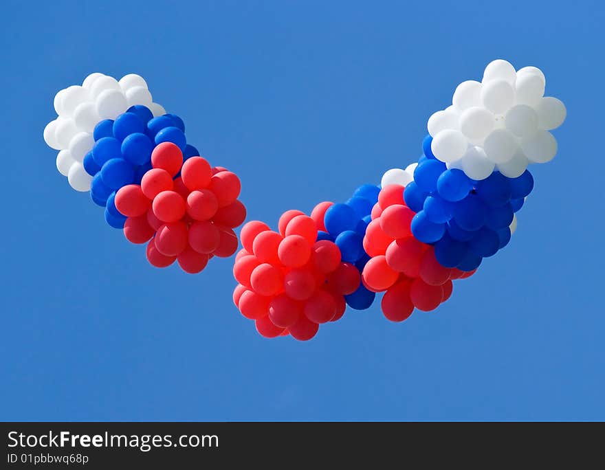 Red, white and blue balloons on a blue sky background