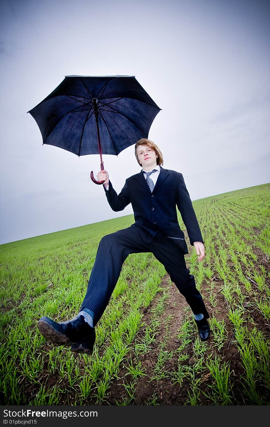 Businessman with umbrella outside, wide angle view