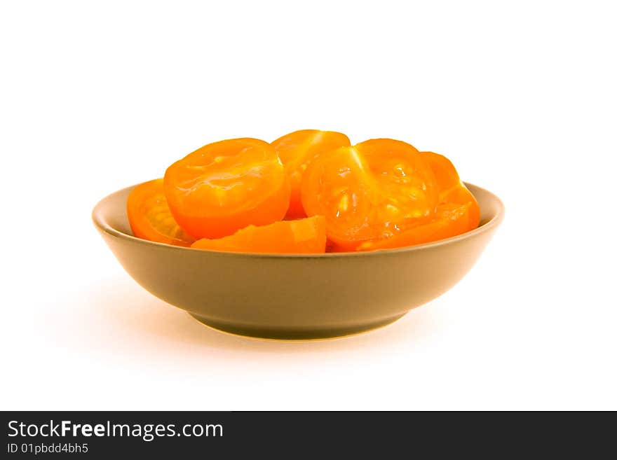 Chopped small red tomatoes in a black bowl on a white background. Chopped small red tomatoes in a black bowl on a white background