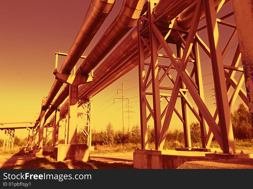 Industrial pipelines on pipe-bridge against blue sky. Industrial pipelines on pipe-bridge against blue sky.