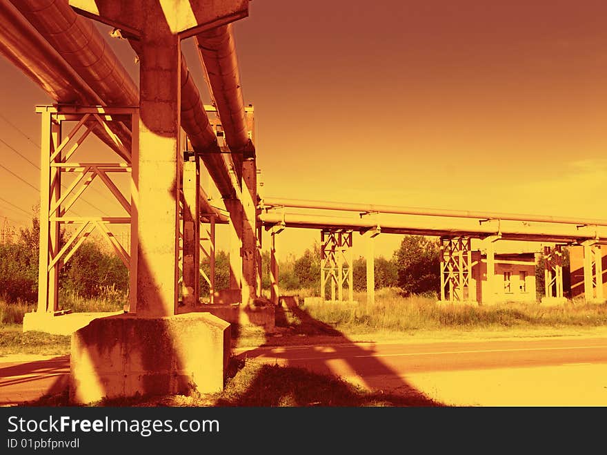 Industrial pipelines on pipe-bridge against blue sky. Industrial pipelines on pipe-bridge against blue sky.