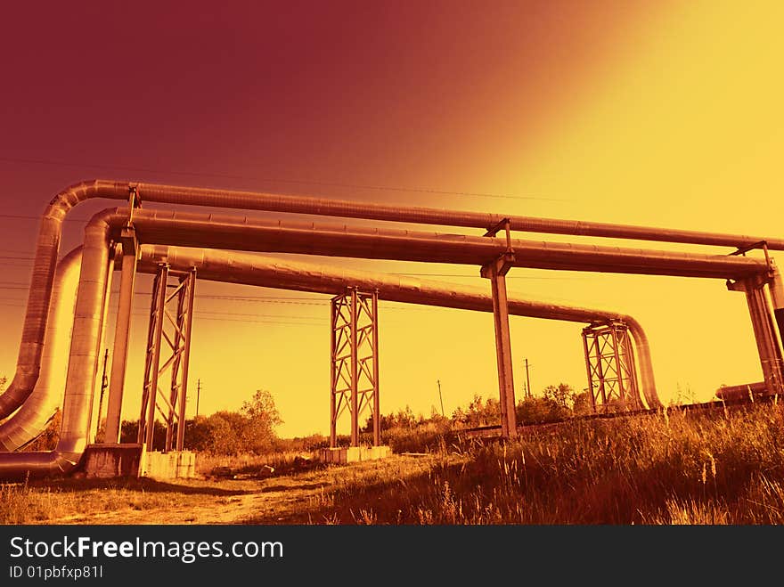 Industrial pipelines on pipe-bridge against blue sky. Industrial pipelines on pipe-bridge against blue sky.