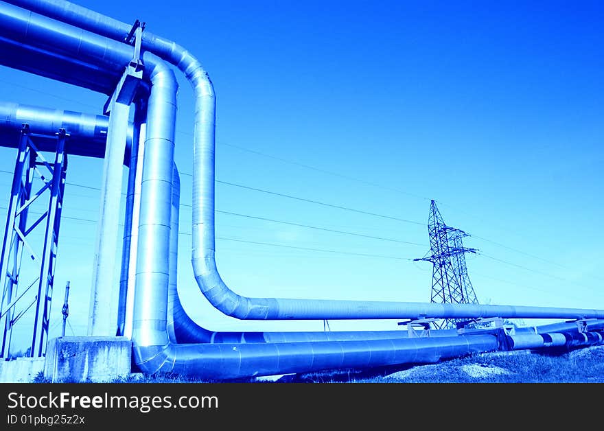 Industrial pipelines on pipe-bridge against blue sky. Industrial pipelines on pipe-bridge against blue sky.