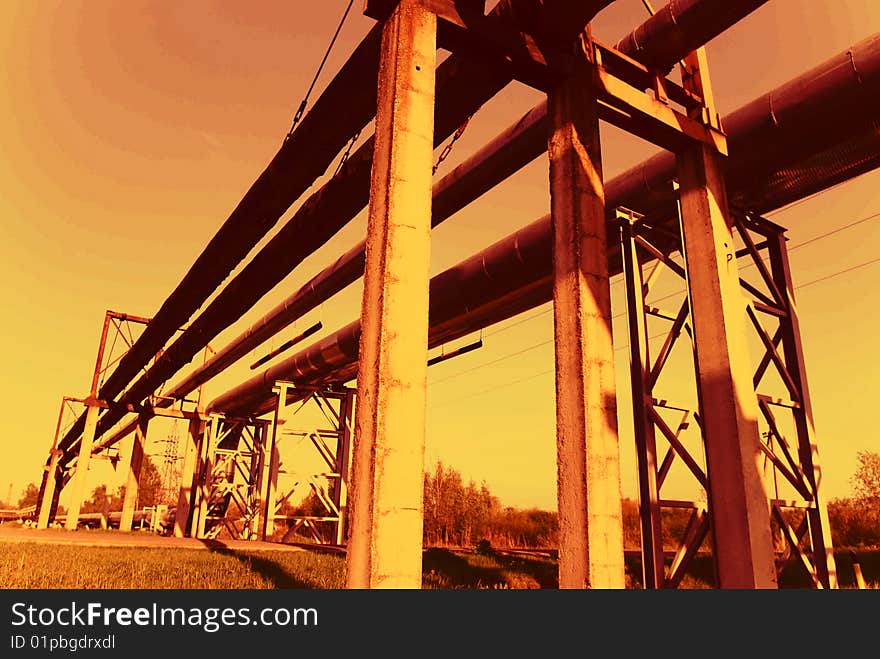 Industrial pipelines on pipe-bridge against blue sky. Industrial pipelines on pipe-bridge against blue sky.