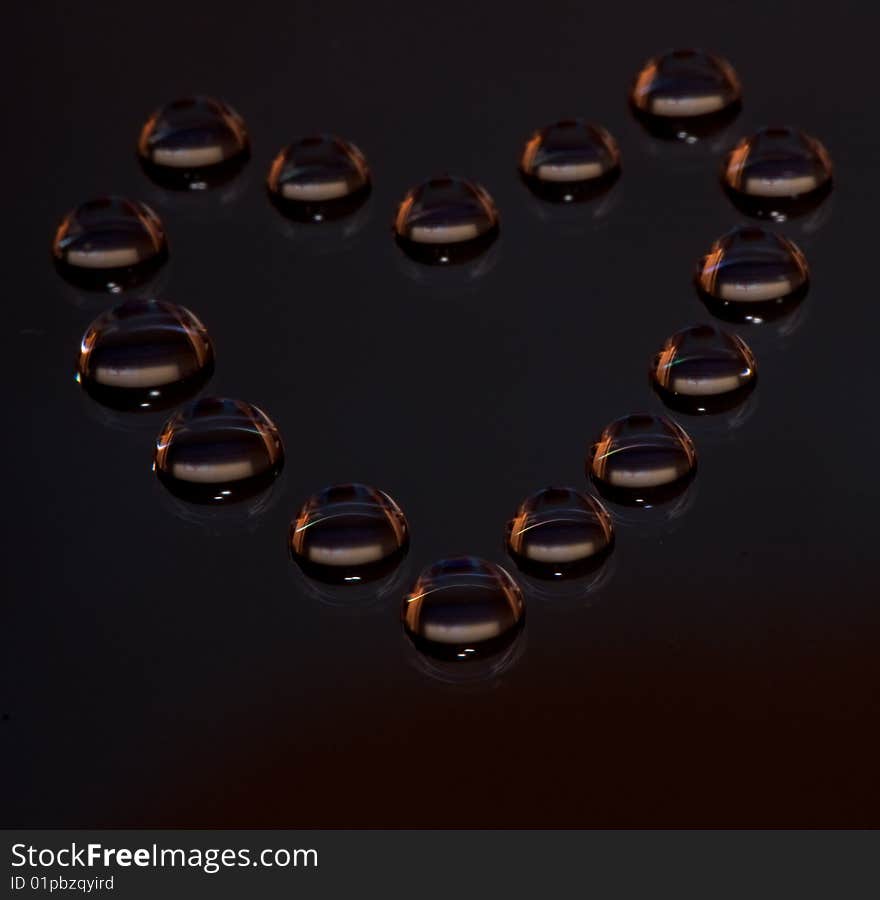 Water drops in the form of heart on a celebratory background