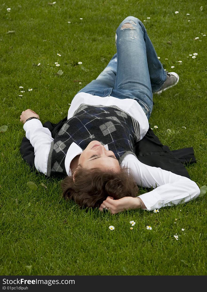 Student girl lays on the grass