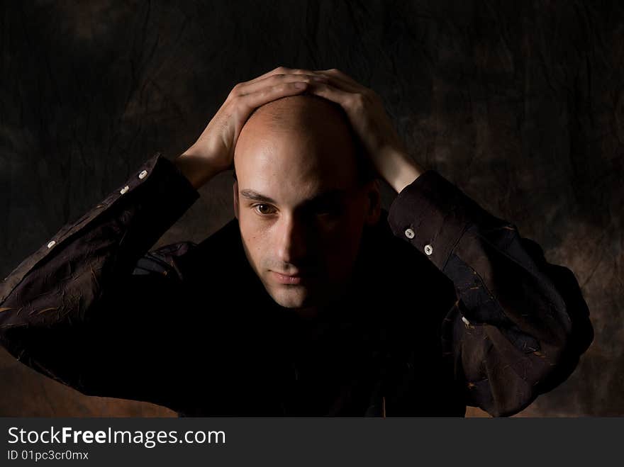 Portrait of young sad male. Dark background