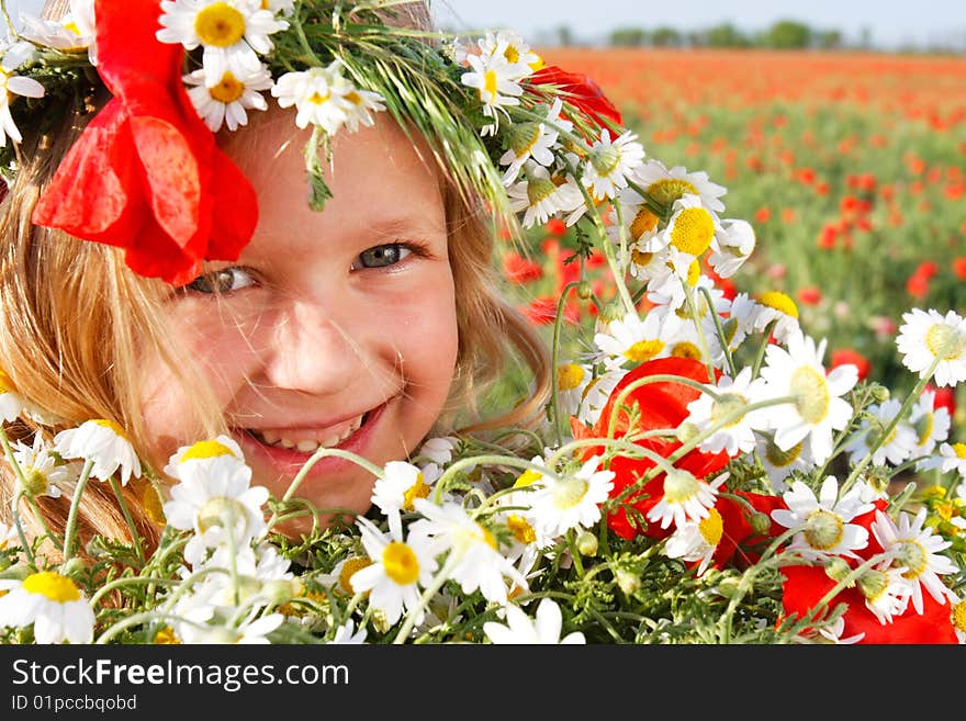 Girl in floral wreath on natural background