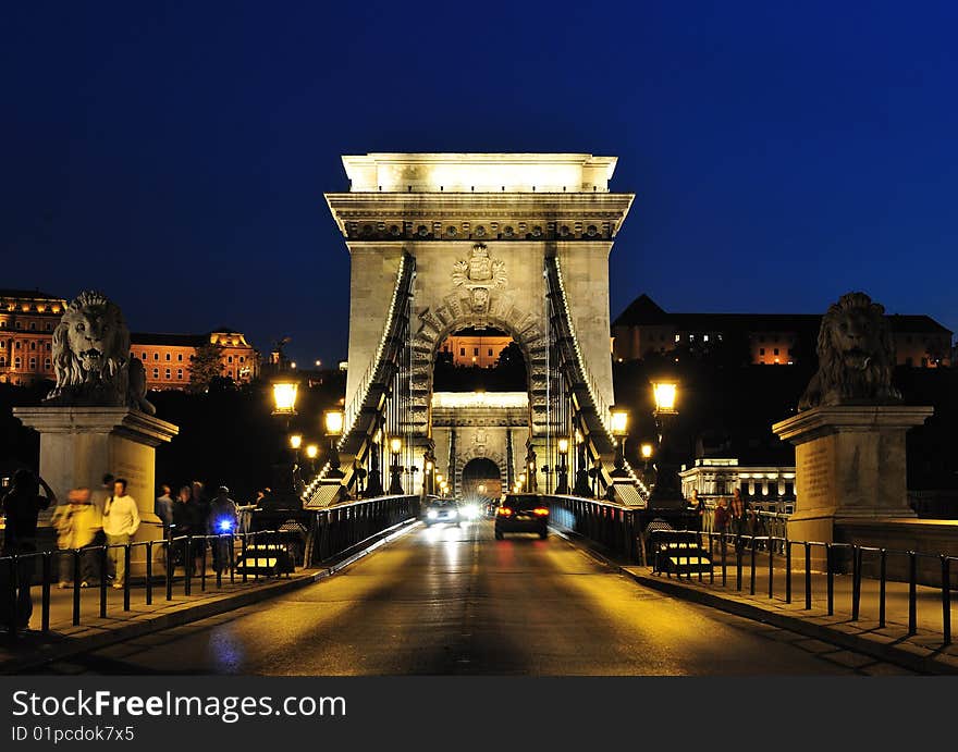 Széchenyi lánchíd or Szechenyi Chain Bridge is a suspension bridge that spans the River Danube between Buda and Pest, the western and eastern sides of Budapest, the capital of Hungary. It was the first permanent bridge across the Danube in Budapest, and was opened in 1849. The bridge had an enormous significance in the country's economics and life. Its decorations made of cast iron, and its construction, radiating calm dignity and balance, raised it among the most beautiful industrial monuments in Europe. It became a symbol of advancement, national awakening, and the linkage between East and West. Széchenyi lánchíd or Szechenyi Chain Bridge is a suspension bridge that spans the River Danube between Buda and Pest, the western and eastern sides of Budapest, the capital of Hungary. It was the first permanent bridge across the Danube in Budapest, and was opened in 1849. The bridge had an enormous significance in the country's economics and life. Its decorations made of cast iron, and its construction, radiating calm dignity and balance, raised it among the most beautiful industrial monuments in Europe. It became a symbol of advancement, national awakening, and the linkage between East and West.