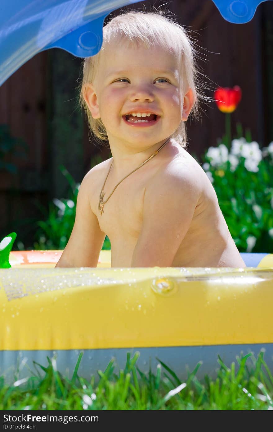 Smiling little girl in yellow pool