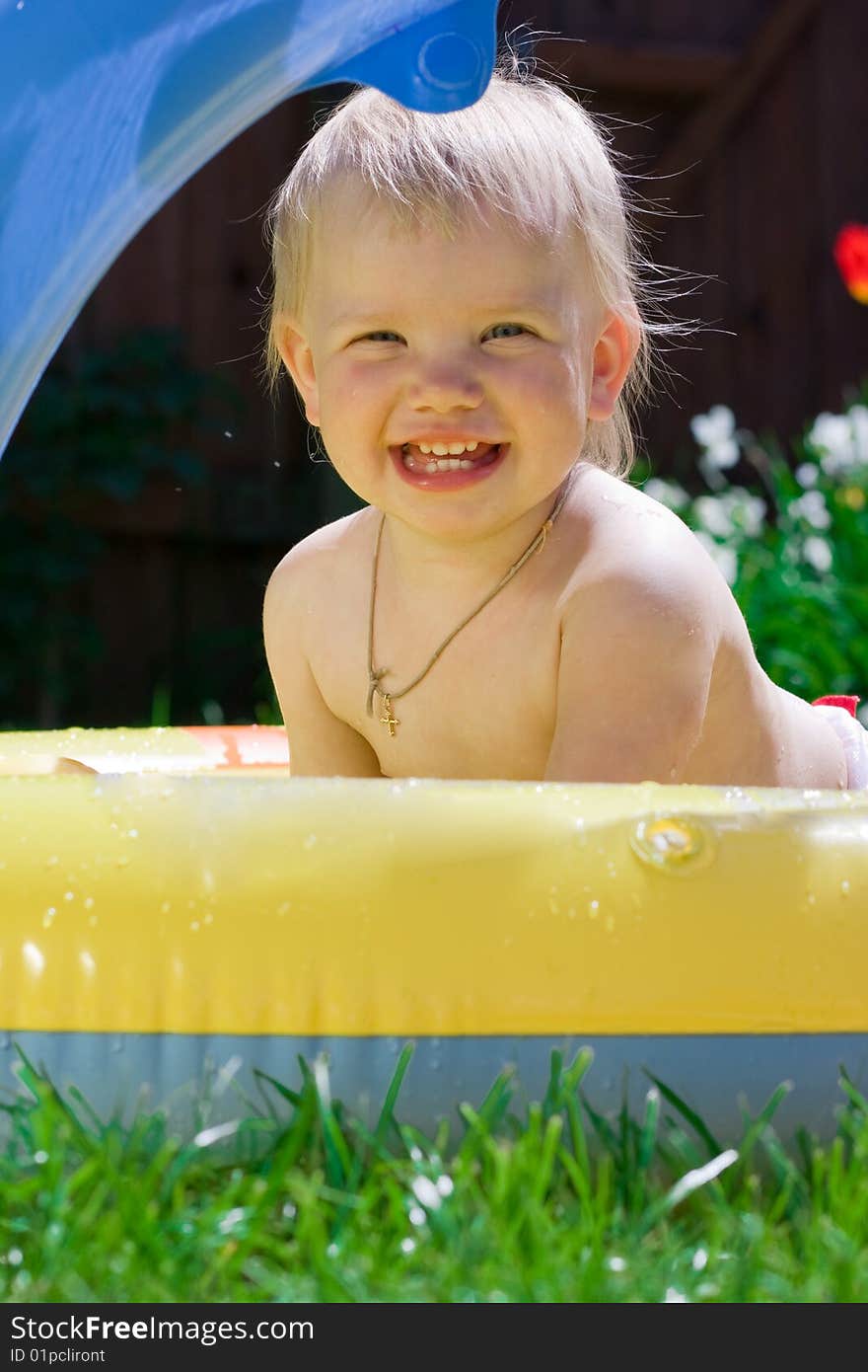 Happy little girl in yellow pool