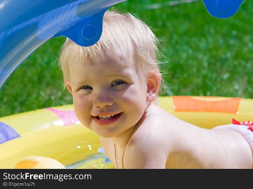 Happy little girl in yellow pool