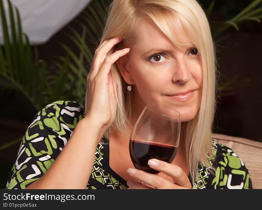 Beautiful Blonde Woman Smiling at an Evening Social Gathering Tasting Wine. Beautiful Blonde Woman Smiling at an Evening Social Gathering Tasting Wine.