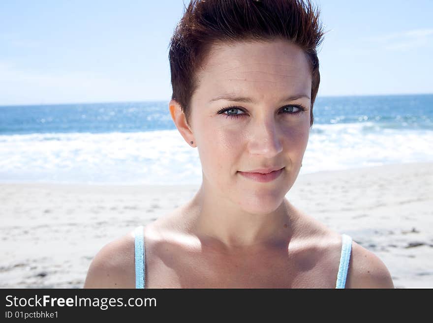 Beautiful Brunette looks at the beach with blue eyes and blue backround