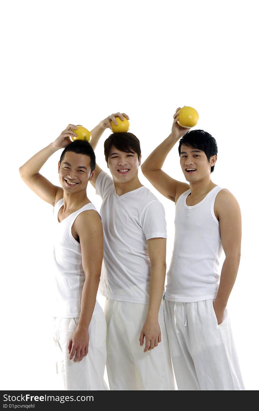 Three young man holding grapefruit on his head. Three young man holding grapefruit on his head