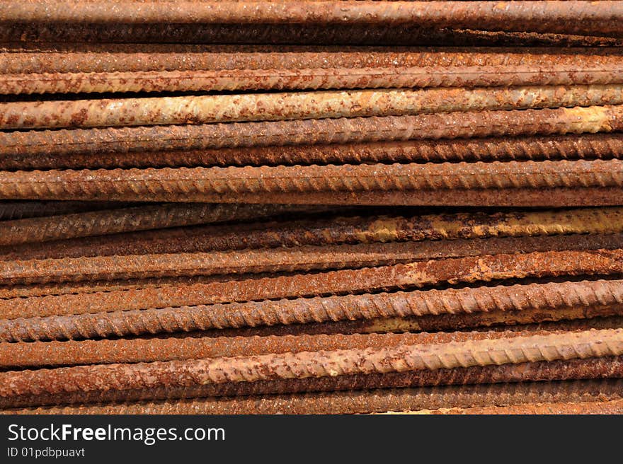 Rusted steel rods form a tough background.