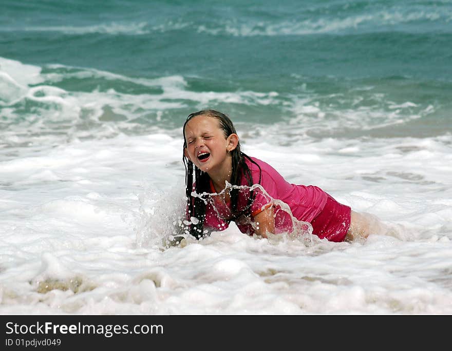 Child laughing after being dumped by a wave