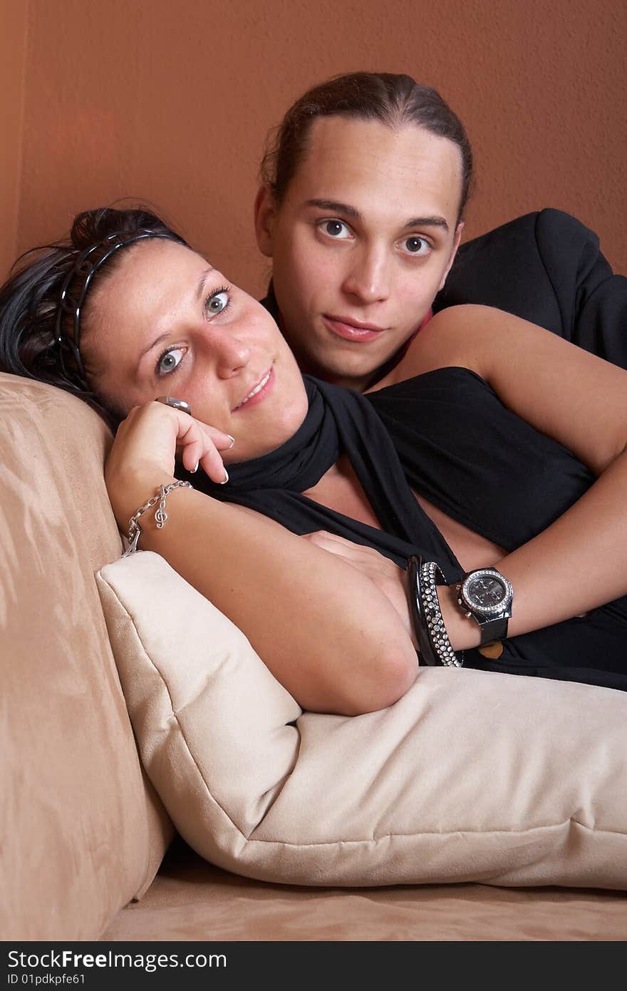 Young couple chilling on a couch at home. Both dressed up nicely. Young couple chilling on a couch at home. Both dressed up nicely.