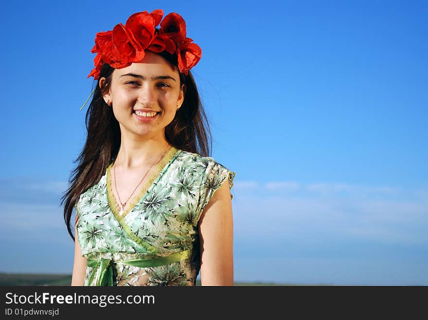 A beautiful girl standing on a field filled with red poppies. A beautiful girl standing on a field filled with red poppies