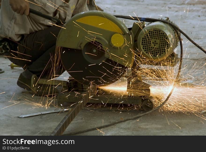 Worker holding a cutting machine in action. Worker holding a cutting machine in action