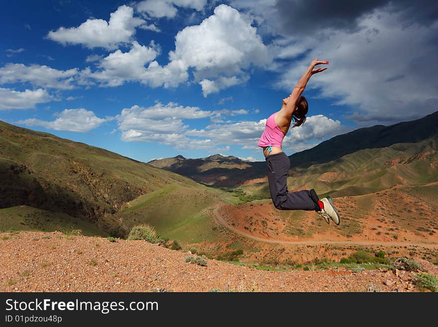 The girl jumping in top in mountains