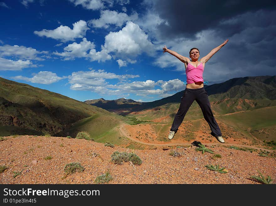 The girl jumping in top in mountains