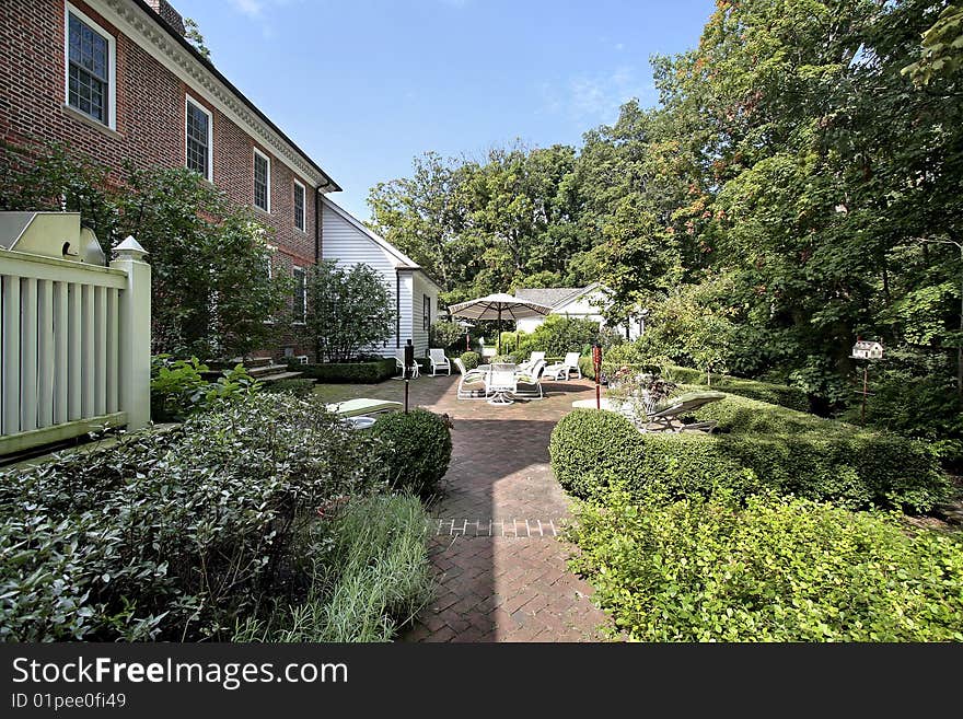 Suburban brick home with patio and bushes