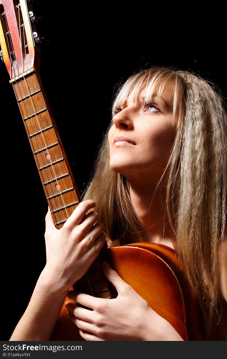 Nice girl with a guitar on a black background