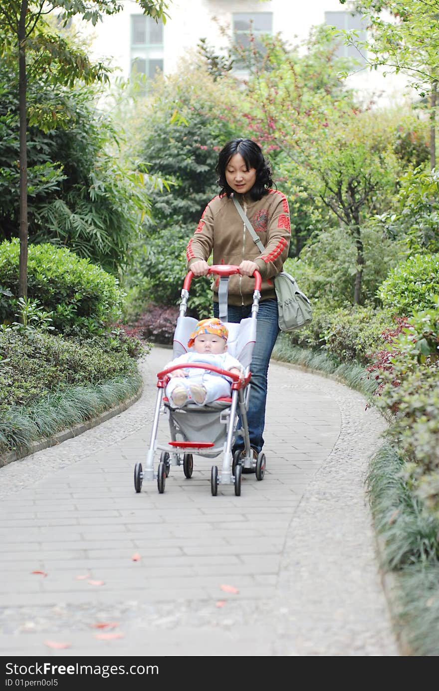 Cute baby boy sit in baby carriage  with his mother. Cute baby boy sit in baby carriage  with his mother