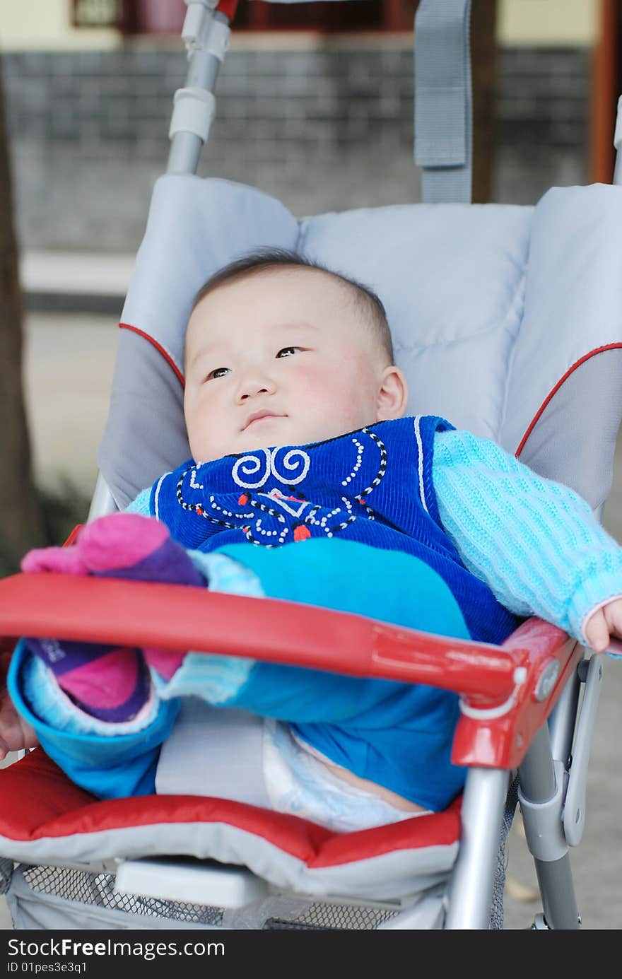 Cute baby siting in red baby carriage