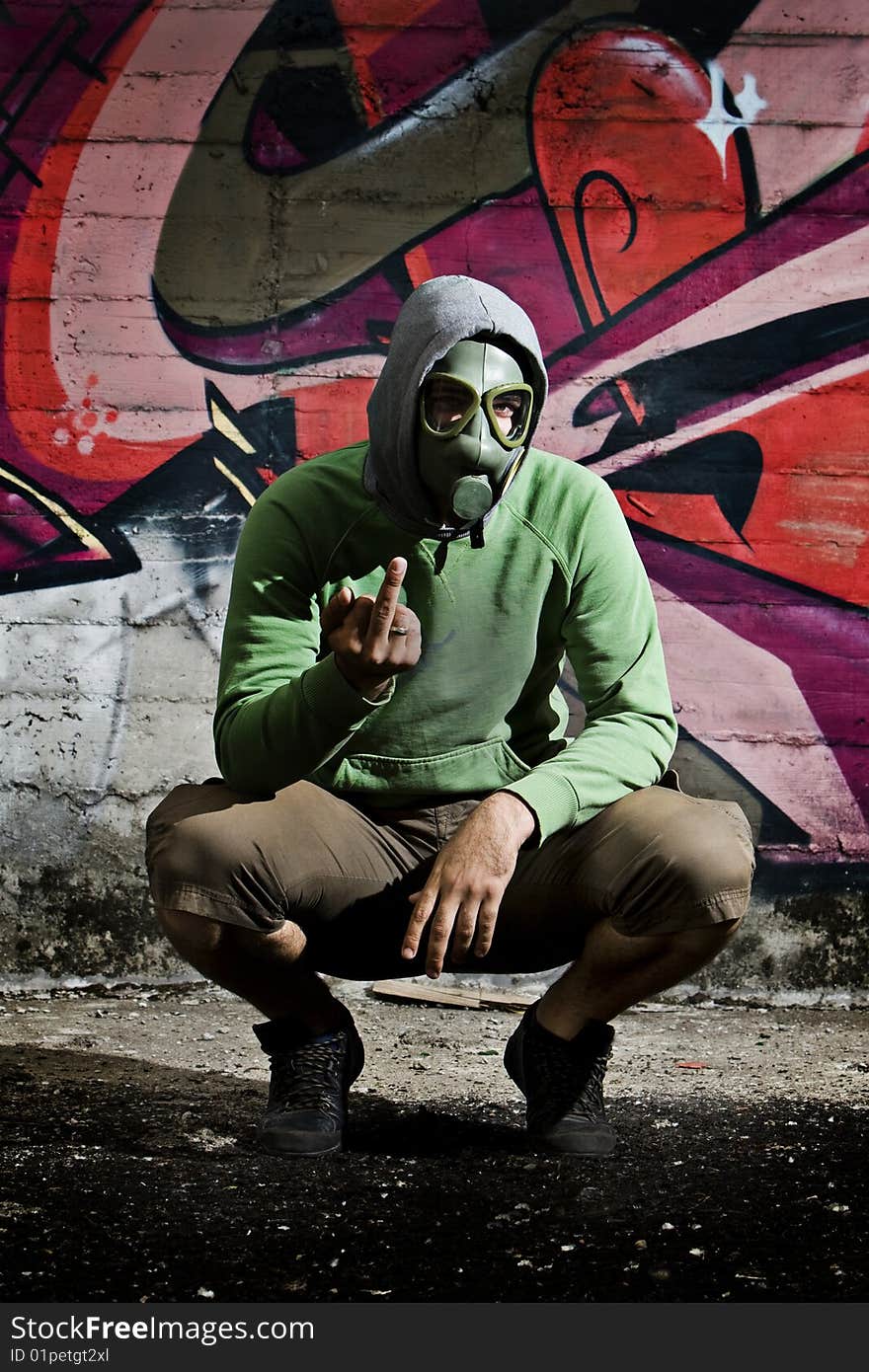 Man wearing gas mask in alley with grafitti background. Man wearing gas mask in alley with grafitti background