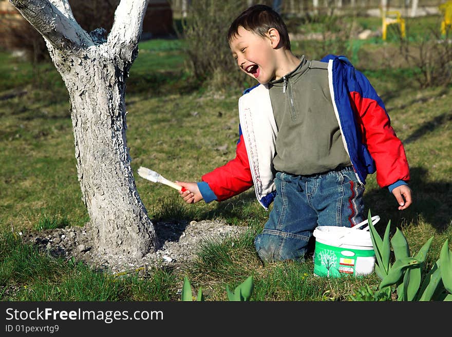 Boy painting apple tree outdoors