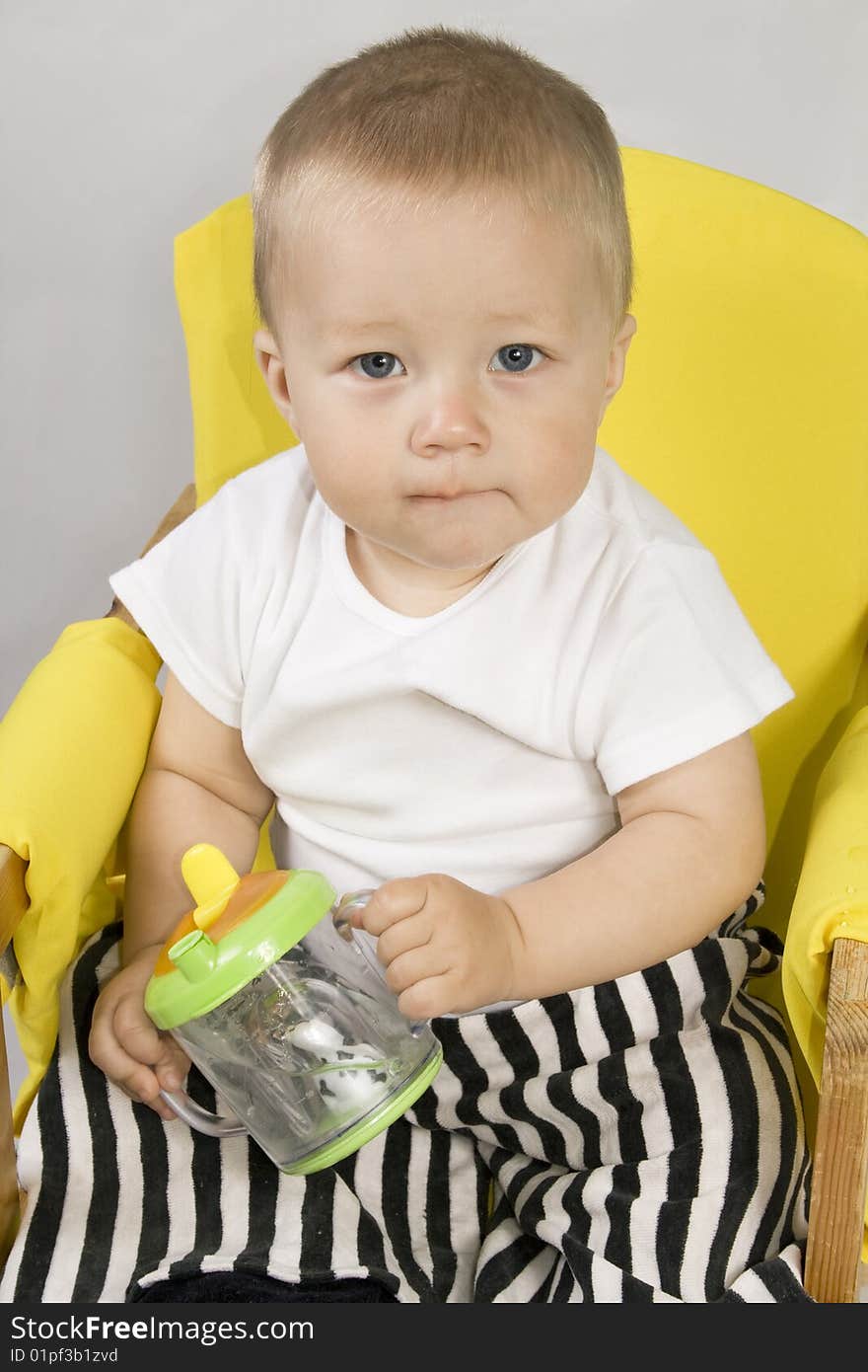 Year old baby holds in his hands bottle with the water. Year old baby holds in his hands bottle with the water.