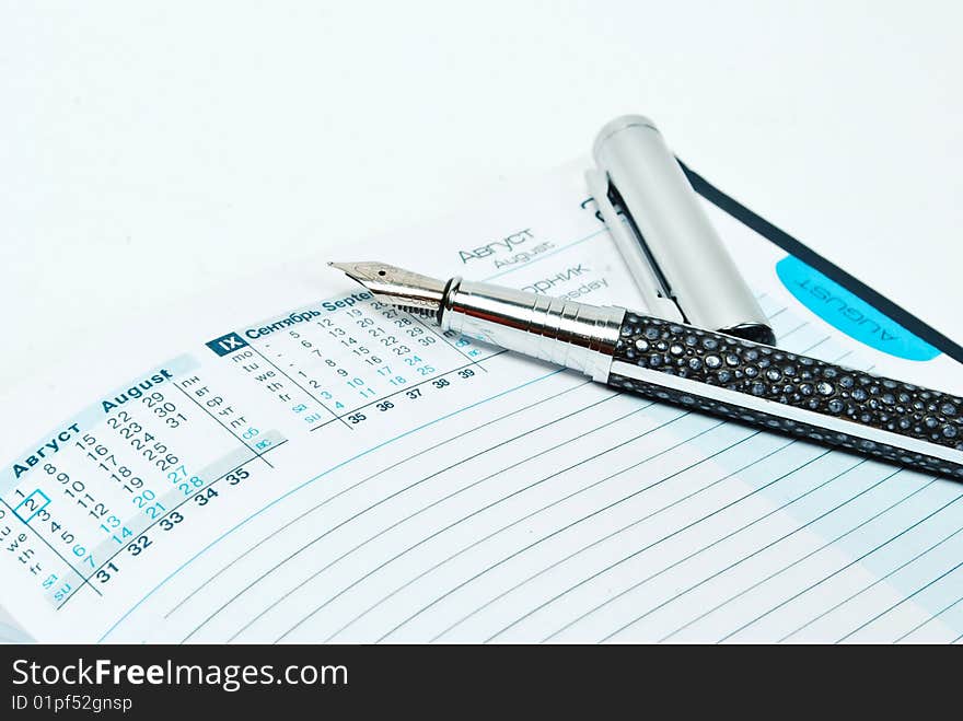 Pen and notebook on white background