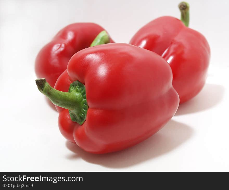 Color photograph of red peppers on a white background