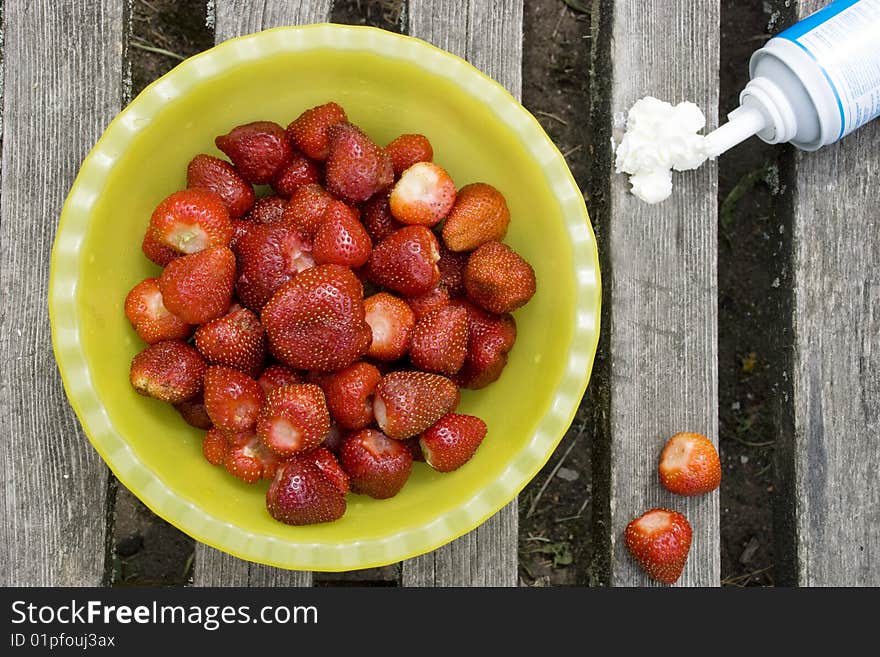 Fresh strawberry with cream on wood