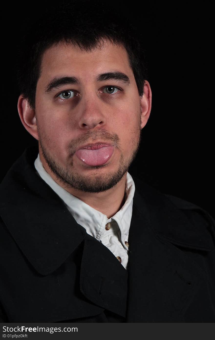 Male portrait with tongue sticking out isolated on black background