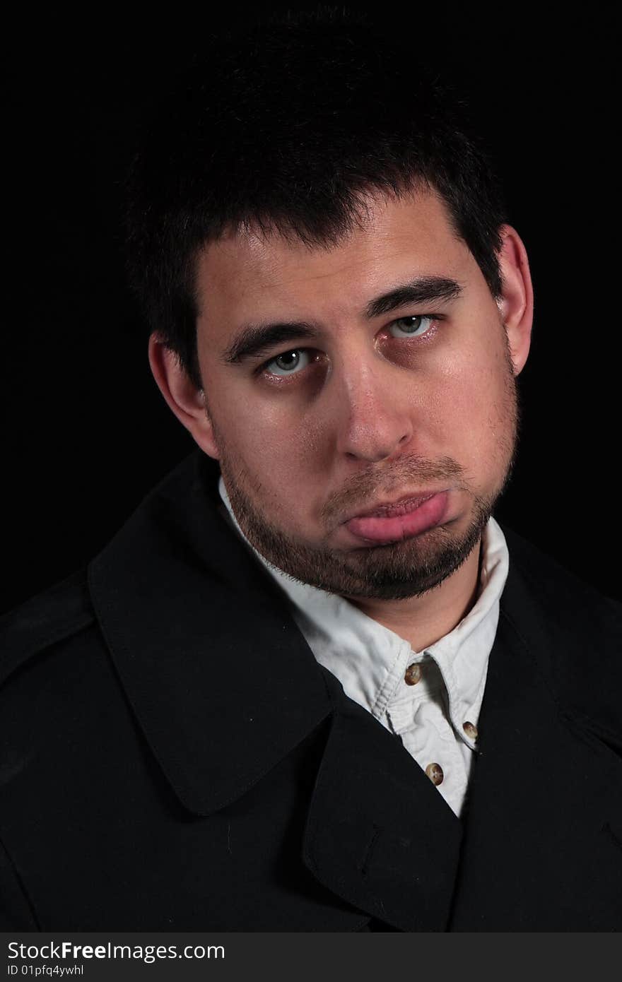 Pouting male portrait isolated on black background