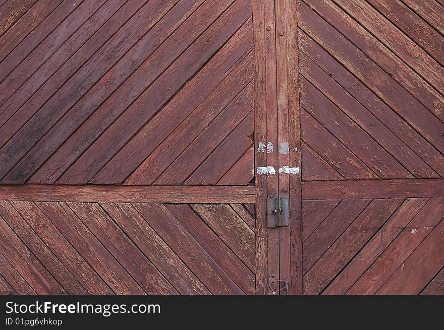 The closed old wooden gate with the cracked brown paint