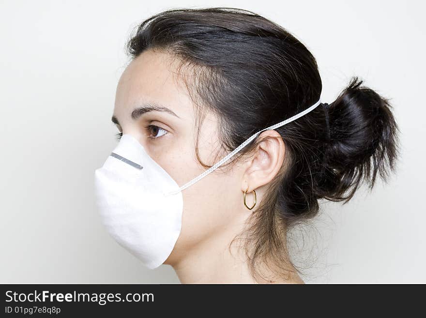 Young woman putting on a mask against swine flu