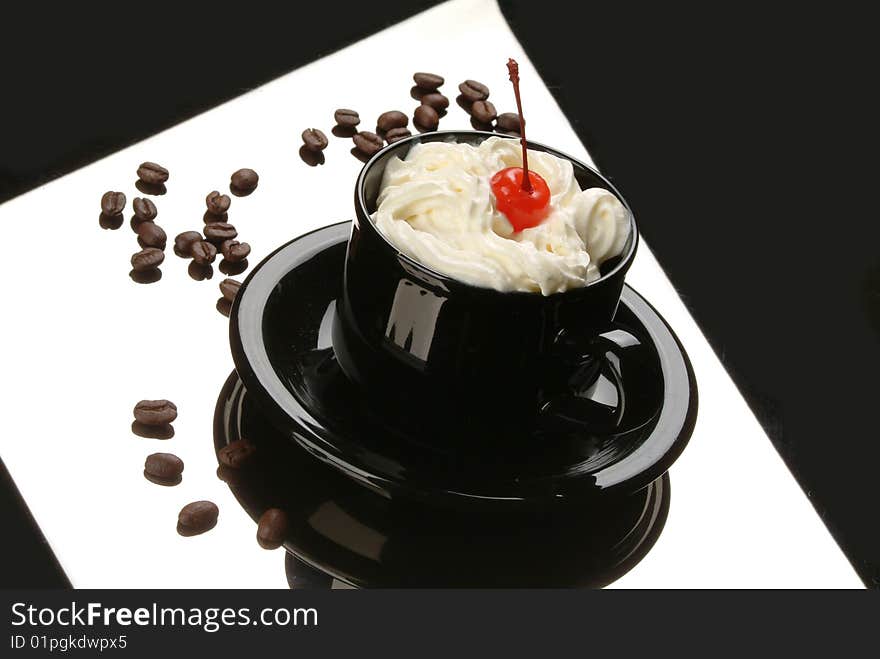 Cup with stirred cream and cherry on a black glass. Cup with stirred cream and cherry on a black glass