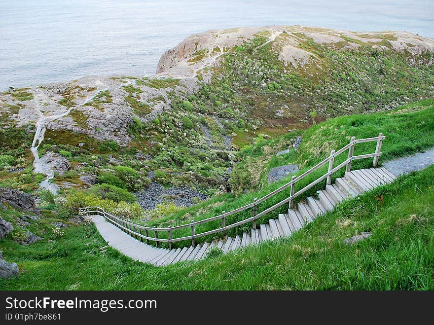 Steps on steep hillside leading to rocky ocean shoreline. Steps on steep hillside leading to rocky ocean shoreline.