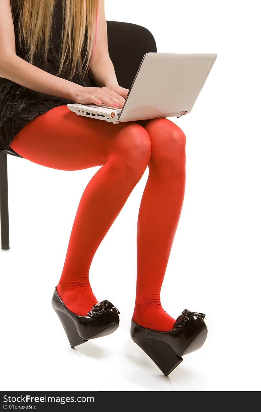 Woman's legs in red stockings and laptop. Isolated