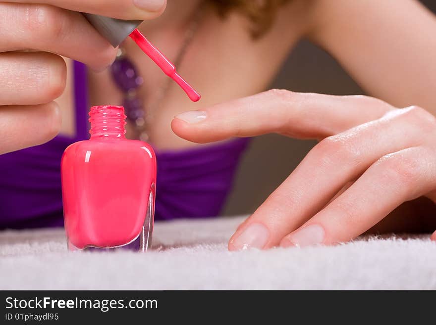 Woman applying red nail polish