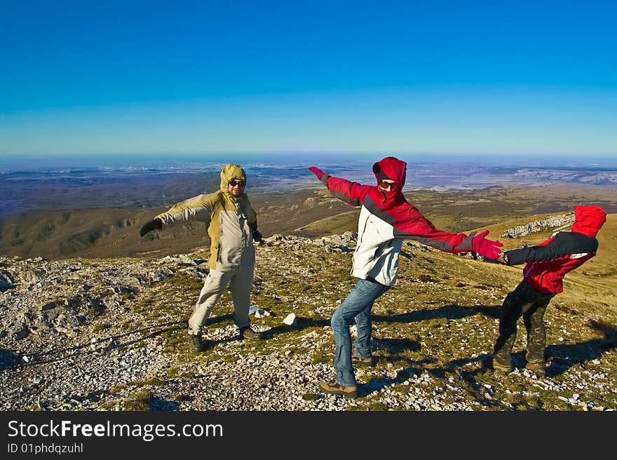 Happy Hikers In Mountains Playing With Strong Wind