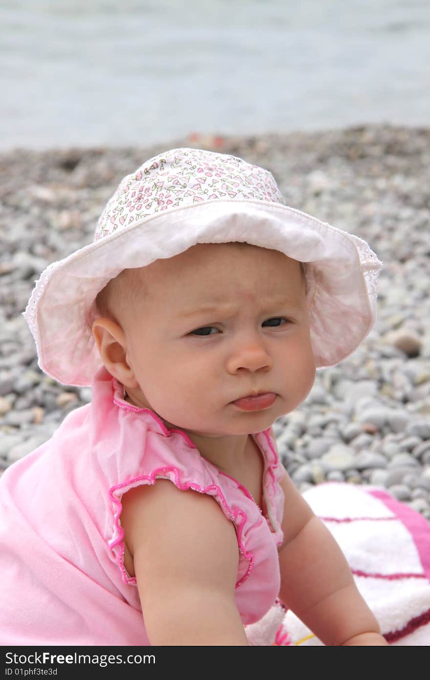 Summer shot - little girl with panama sitting on the beach. Summer shot - little girl with panama sitting on the beach