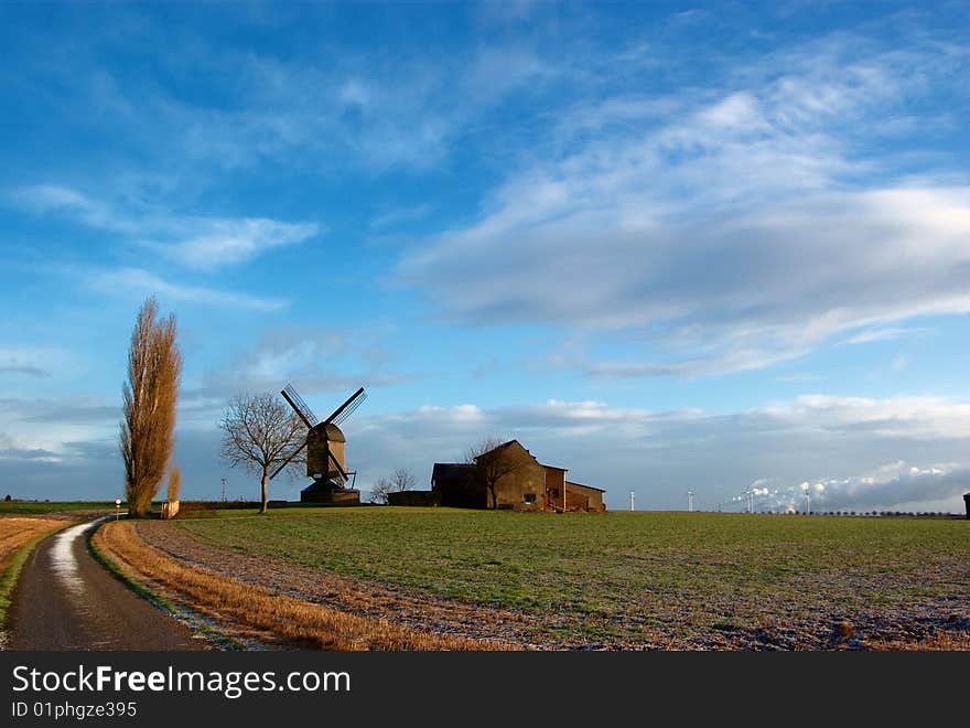 Morning light,field, traditional windmill and house, modern windmill generators on a background. Morning light,field, traditional windmill and house, modern windmill generators on a background