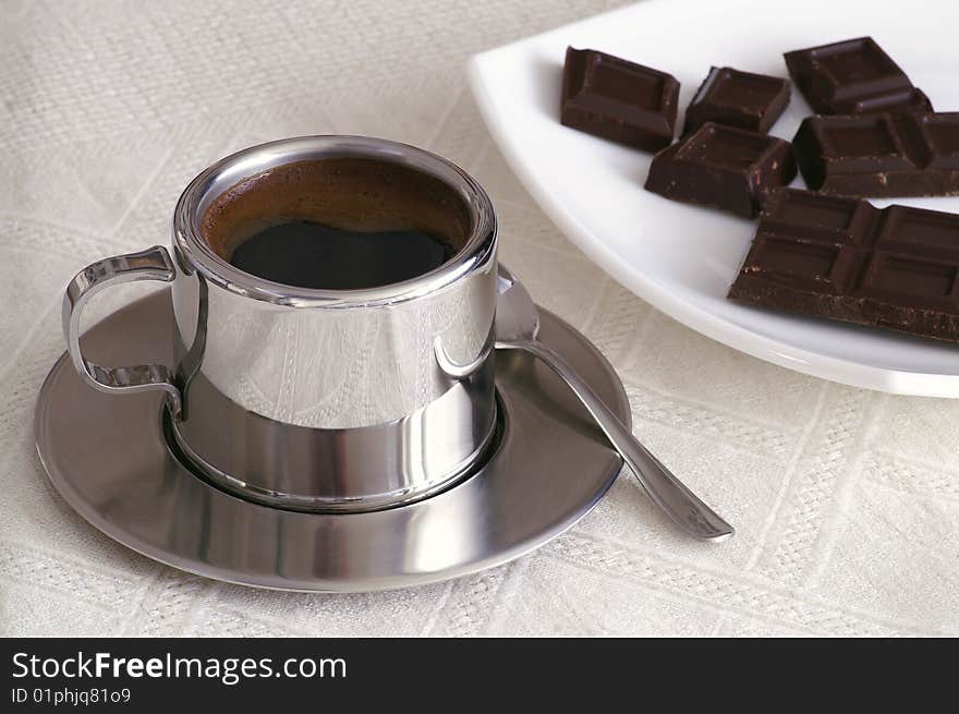 Cup of coffee slices of chocolate on a table. Cup of coffee slices of chocolate on a table