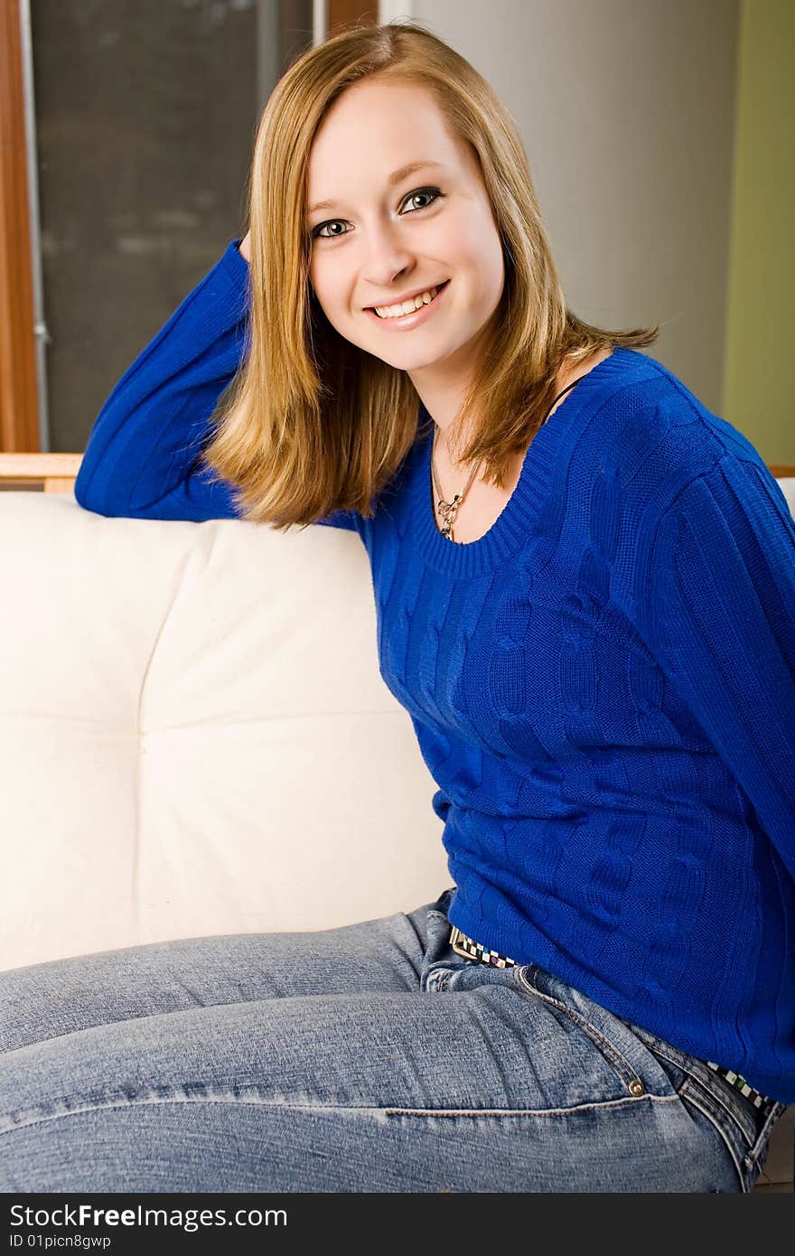 Cute fifteen year old relaxing on a futon sofa. Cute fifteen year old relaxing on a futon sofa.